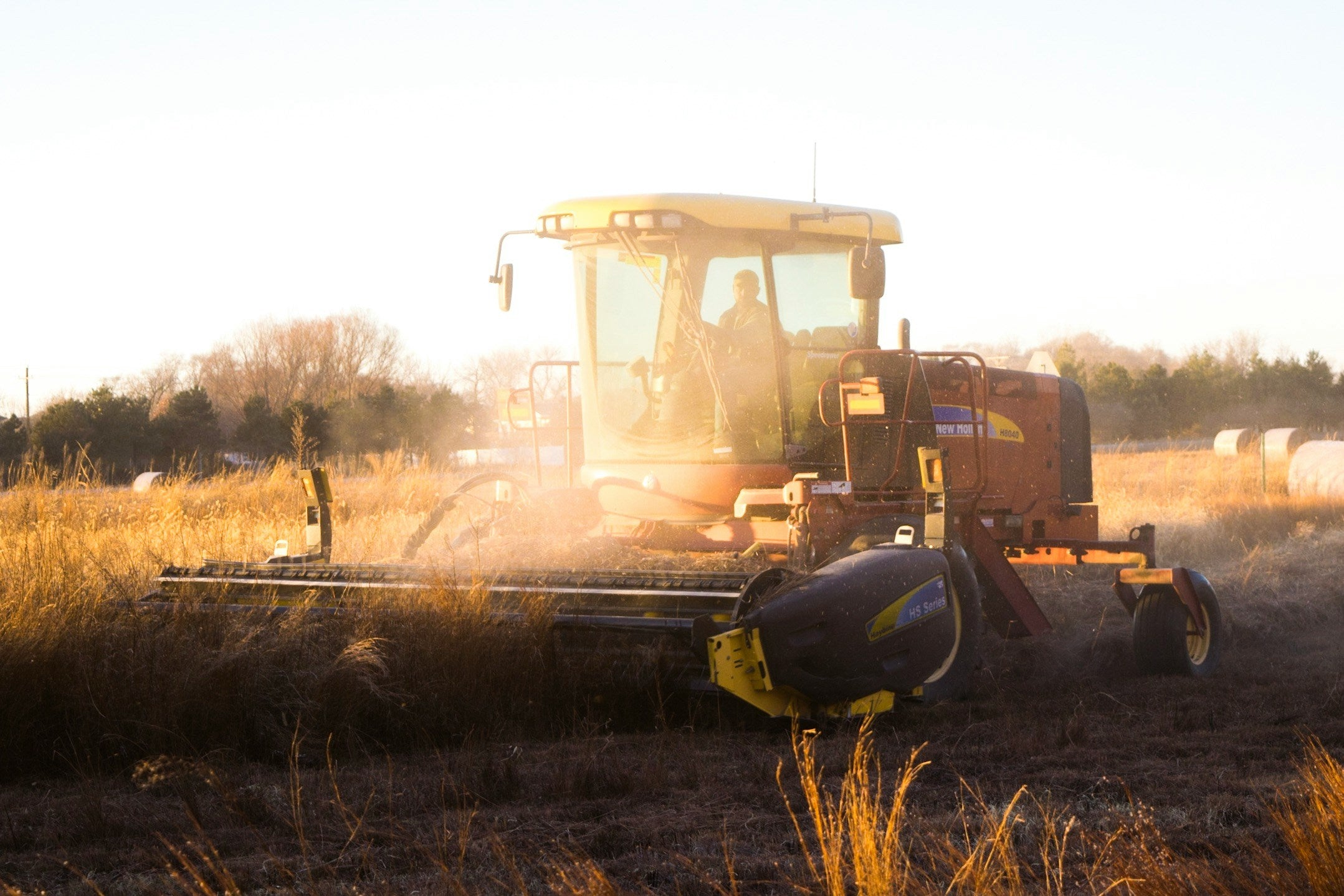 Tractor working in a field with sunset lighting