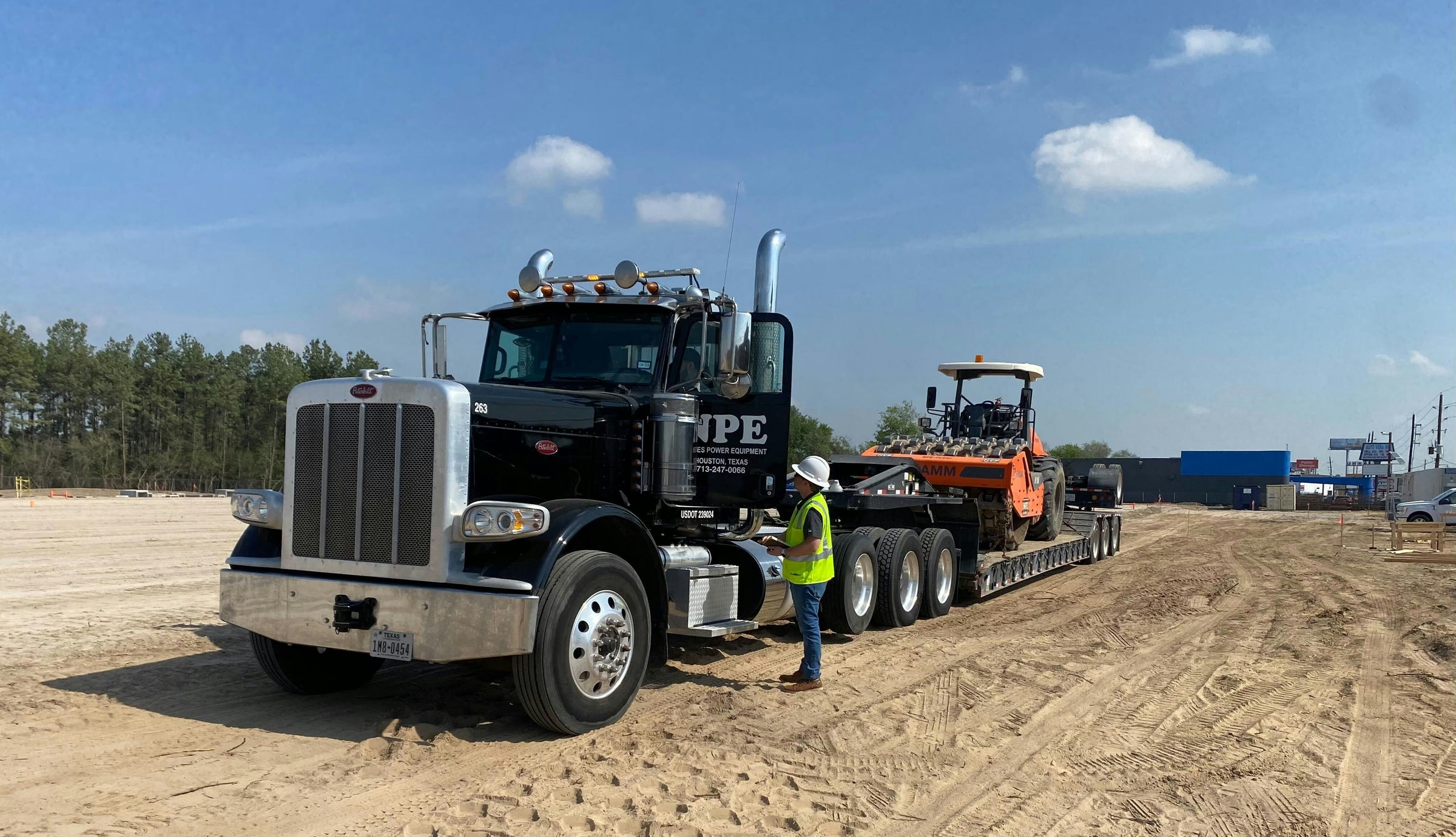 Trucking fleet carrying construction equipment.